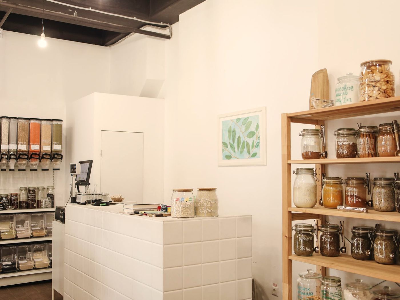 A bright, minimal shop interior with a counter and wooden shelves